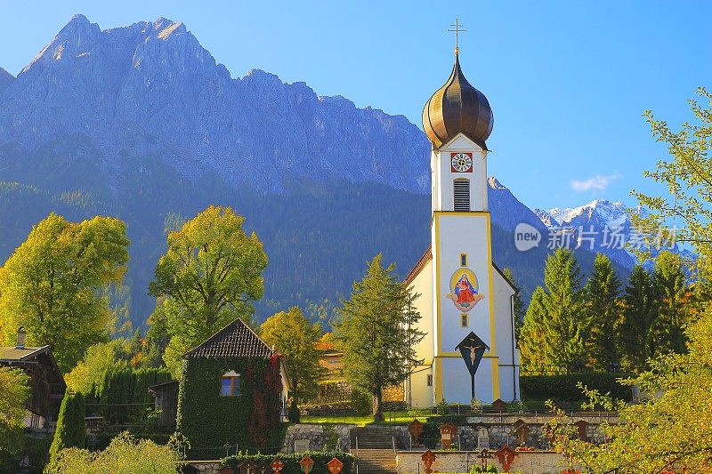 巴洛克式的圣约翰尼斯德尔Täufer教堂在Grainau阿尔卑斯村与Zugspitze, Waxenstein和Alpspitze景观-戏剧性的风景在巴伐利亚阿尔卑斯山，德国，附近的Karwendel山脉-雄伟的高山景观秋天-加尔米施，德国巴伐利亚